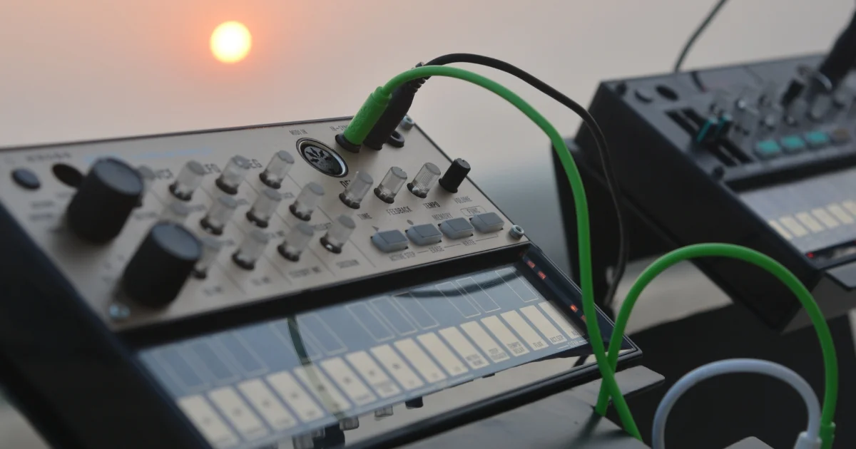 Electronic music synthesizer with green patch cables and control knobs